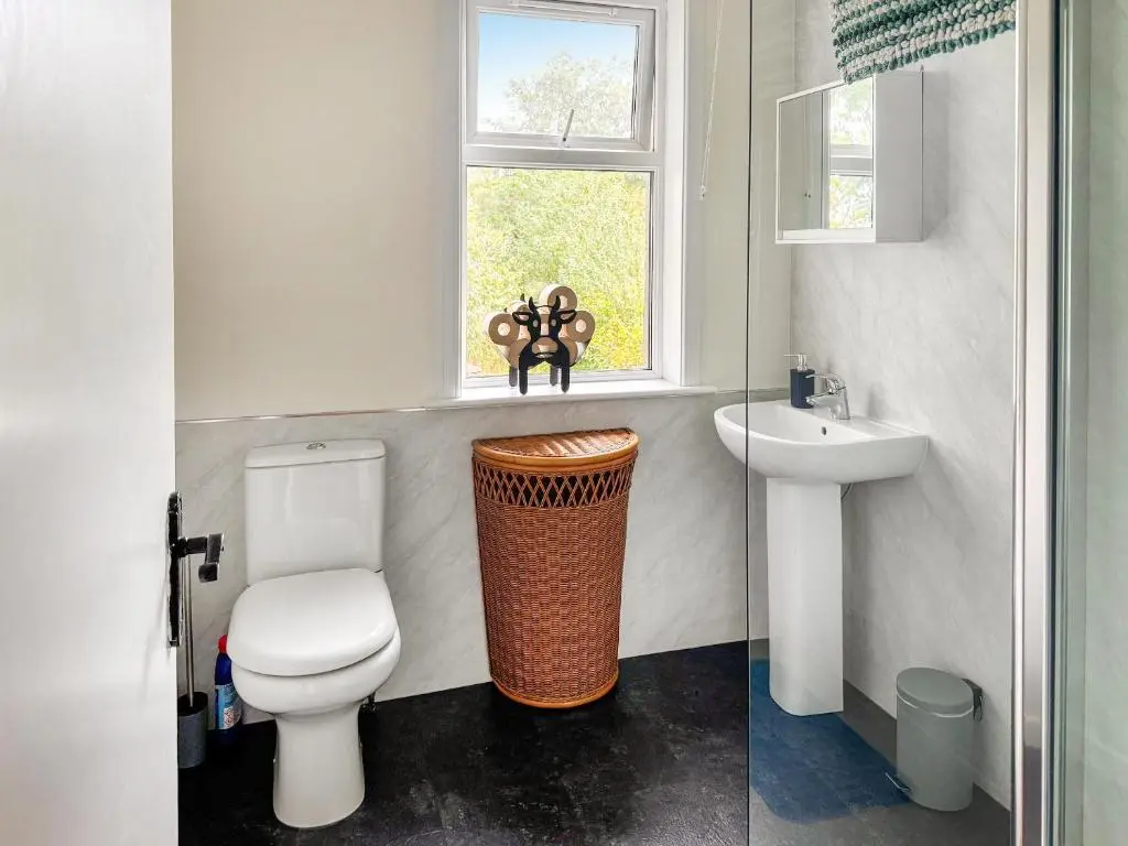a bathroom with a toilet and a sink and a window at Damil Cottage - Uk44789 in Bridge of Alford