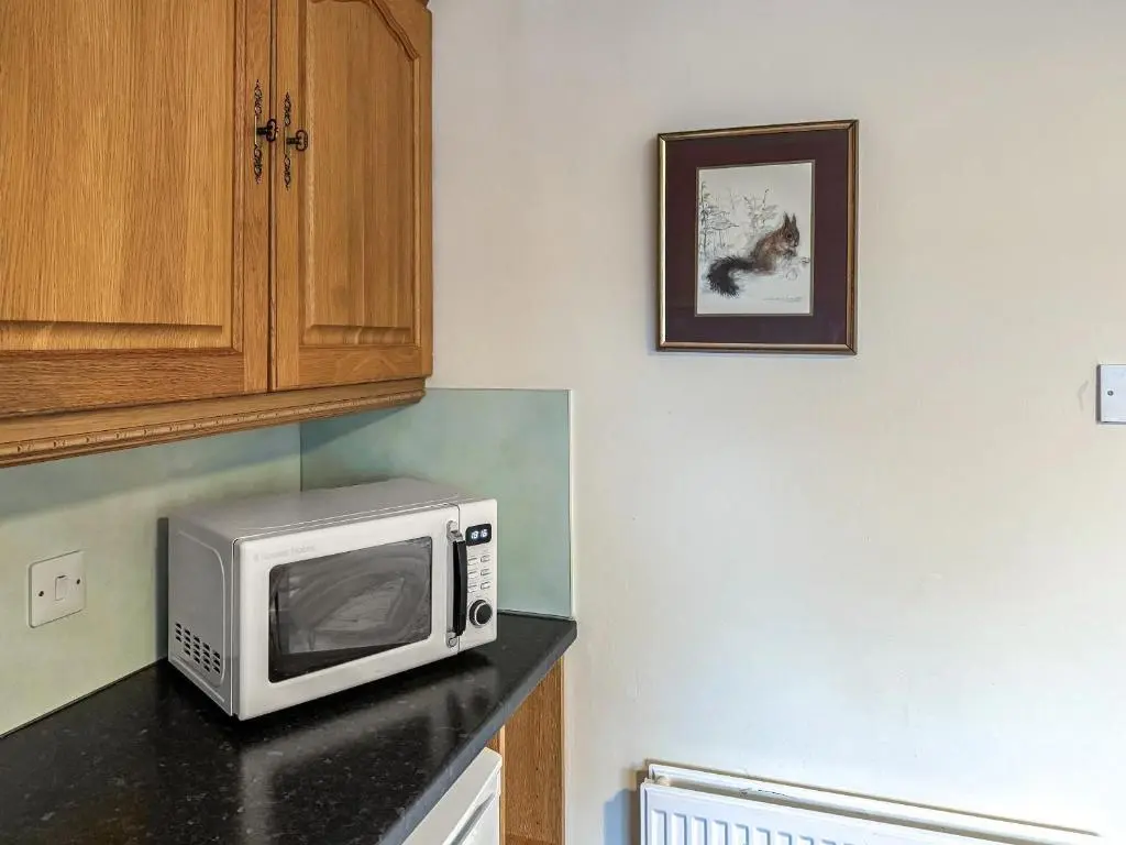 a microwave sitting on a counter in a kitchen at Damil Cottage - Uk44789 in Bridge of Alford
