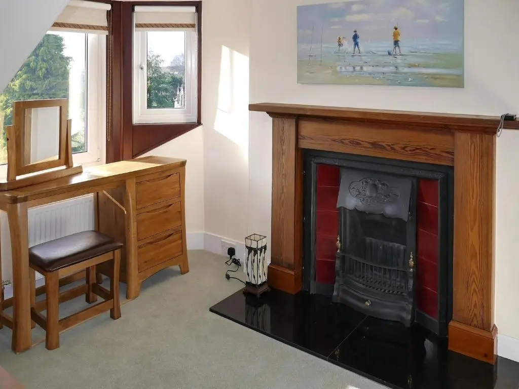 a room with a desk and a fireplace at Tali Ayer in Nairn
