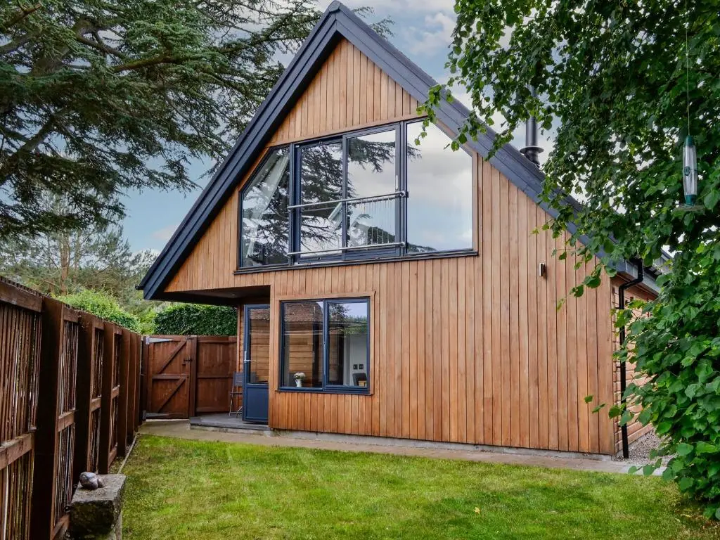 a house with a gambrel roof and windows at Cedar Cottage in Aboyne