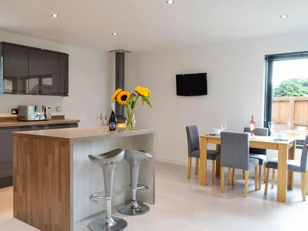 a kitchen and dining room with a table and chairs at Cedar Cottage in Aboyne