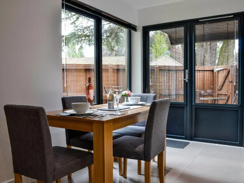 a dining room with a wooden table and chairs at Cedar Cottage in Aboyne