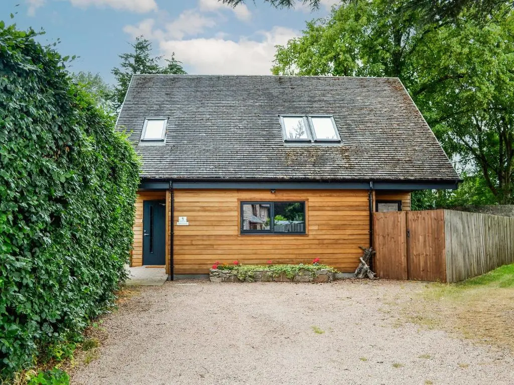 a small house with a window and a fence at Cedar Cottage in Aboyne