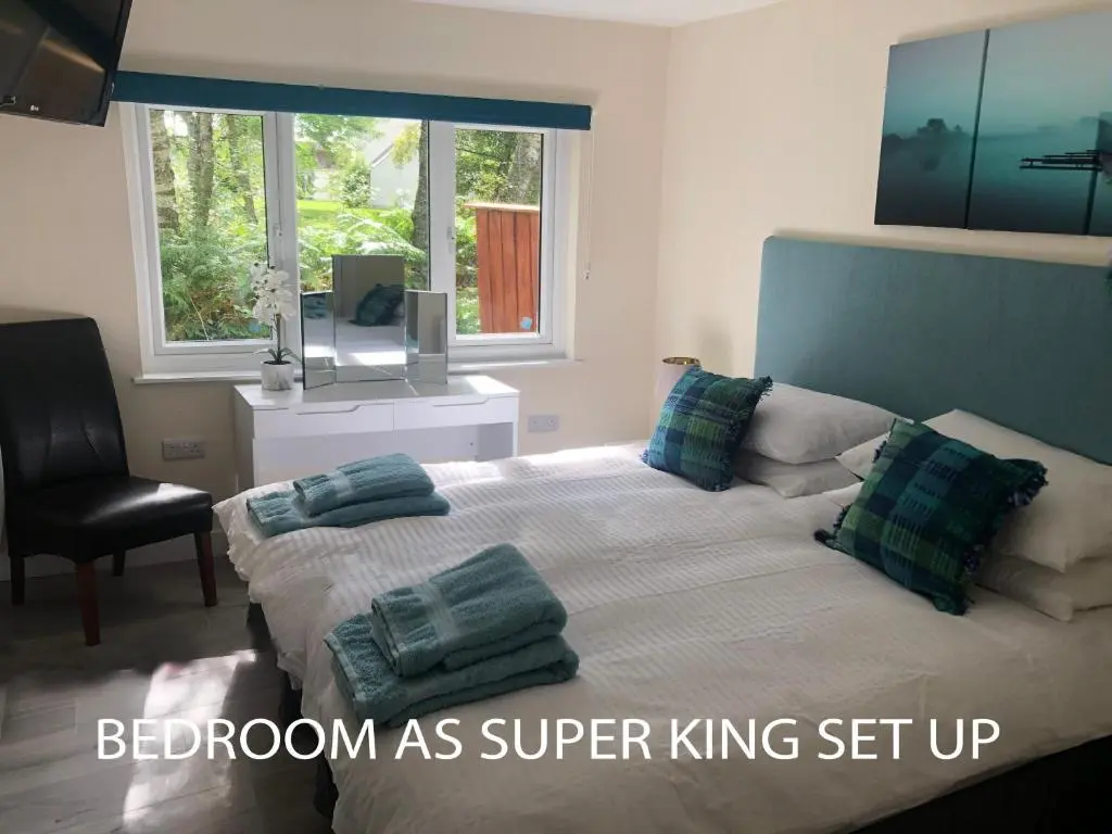 a bedroom with a bed with pillows and a chair at The South Cabin at Easter Arr in Nairn