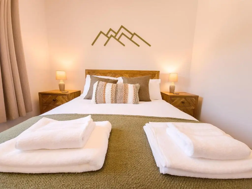a bedroom with two beds with white towels on them at 4 Ben Avon in Aviemore