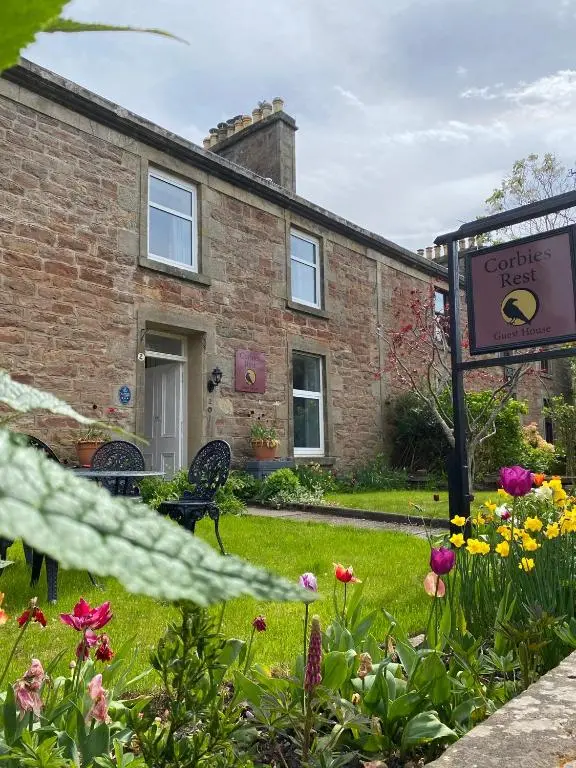 a house with a sign and flowers in the yard at Room Only Corbies Rest in Inverness