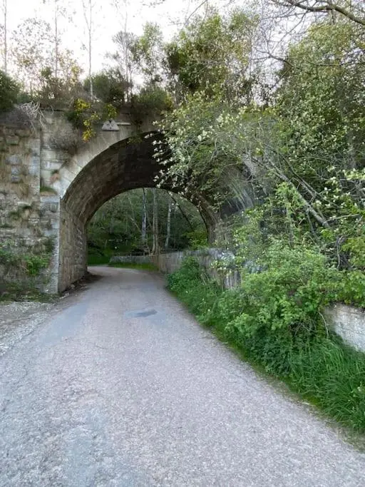a stone bridge over a dirt road next to a path at Perfect for country lovers in Grantown on Spey