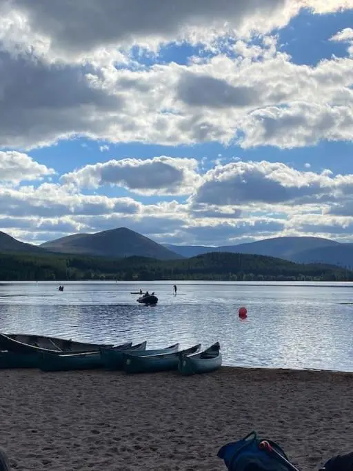 a group of boats sitting on the shore of a lake at Perfect for country lovers in Grantown on Spey