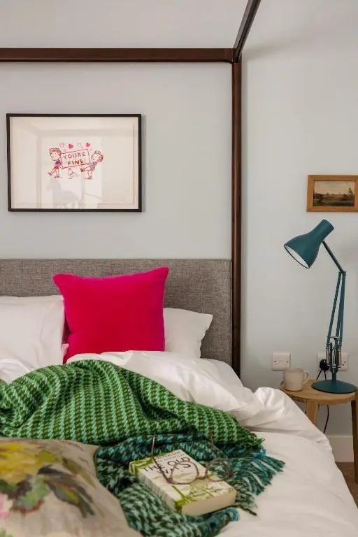 a bedroom with a bed with a red pillow at The Corner House in Banchory