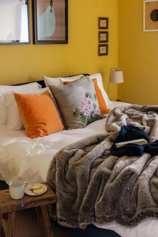 a bedroom with a bed with a blanket and a table at The Corner House in Banchory