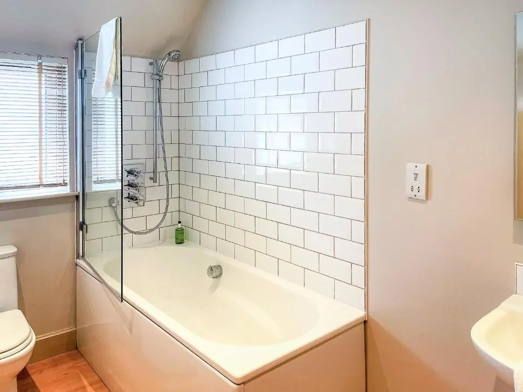 a bathroom with a tub and a toilet and a sink at Brandy Cottage - Ukc6855 in Millton of Clova