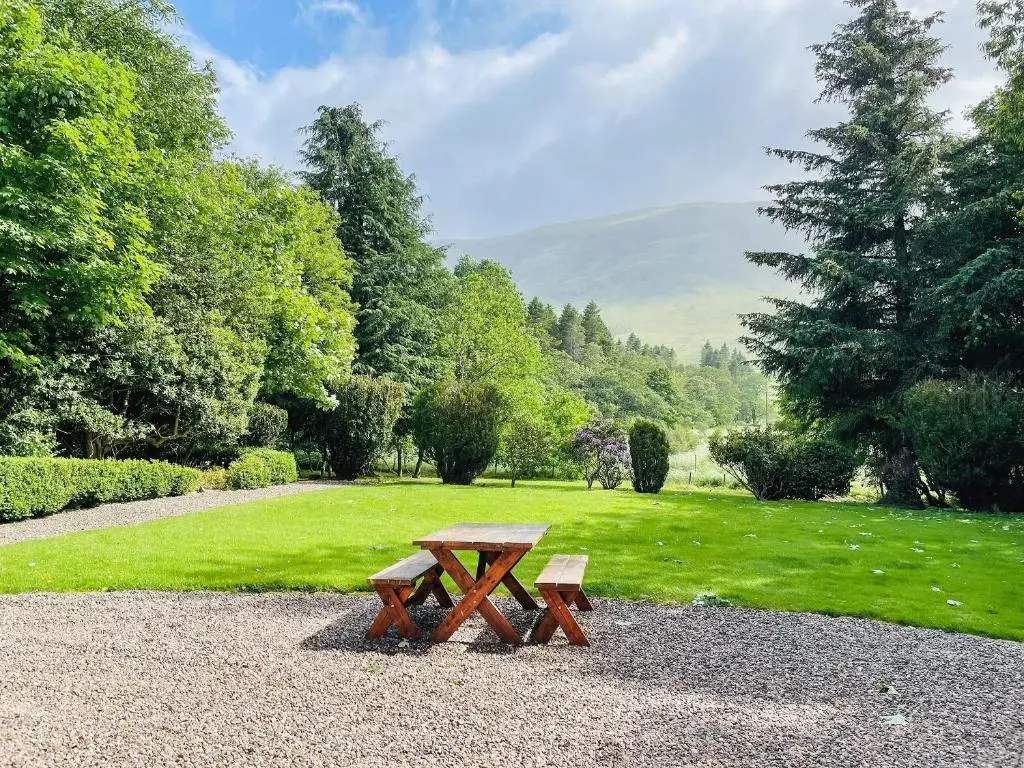 a picnic table in a park with a field and trees at The Old Manse - Ukc6854 in Millton of Clova