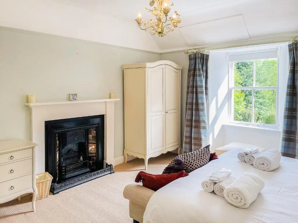 a bedroom with a bed and a fireplace at The Old Manse - Ukc6854 in Millton of Clova