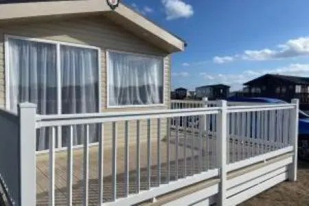 a white fence in front of a house at Silver sands holiday park in Lossiemouth
