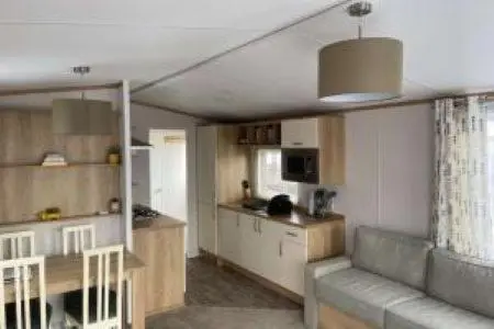 a living room with a couch and a kitchen at Silver sands holiday park in Lossiemouth
