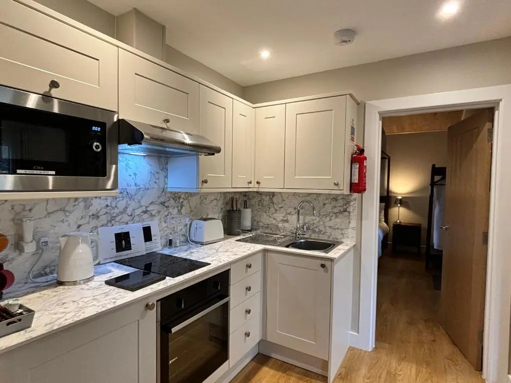a kitchen with white cabinets and a counter top at Breckland Lodge 2 with Hot Tub in Belladrum