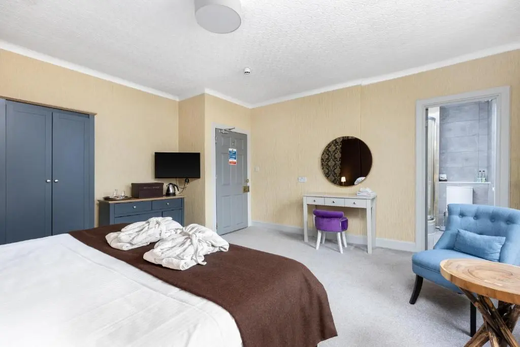 a bedroom with a bed and a table and a chair at Dornoch Castle Hotel in Dornoch