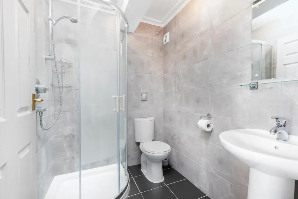 a bathroom with a shower and a toilet and a sink at Dornoch Castle Hotel in Dornoch