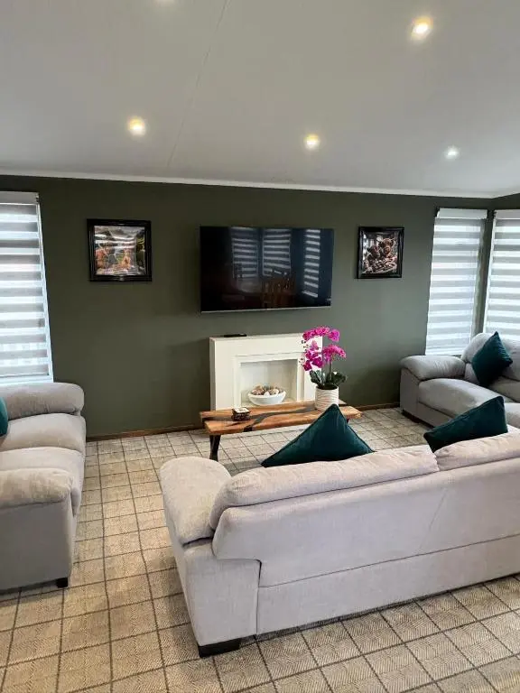 a living room with two couches and a fireplace at Clochnaben lodge in Strachan