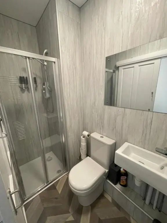 a bathroom with a toilet and a shower and a sink at Crown \u00e0ros beag, Ultra City Central 2 bedroom apartment with free parking onsite in Inverness