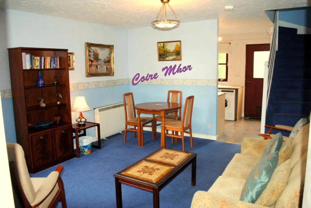 a living room with a table and chairs at Cairngorm Highland Bungalows in Aviemore