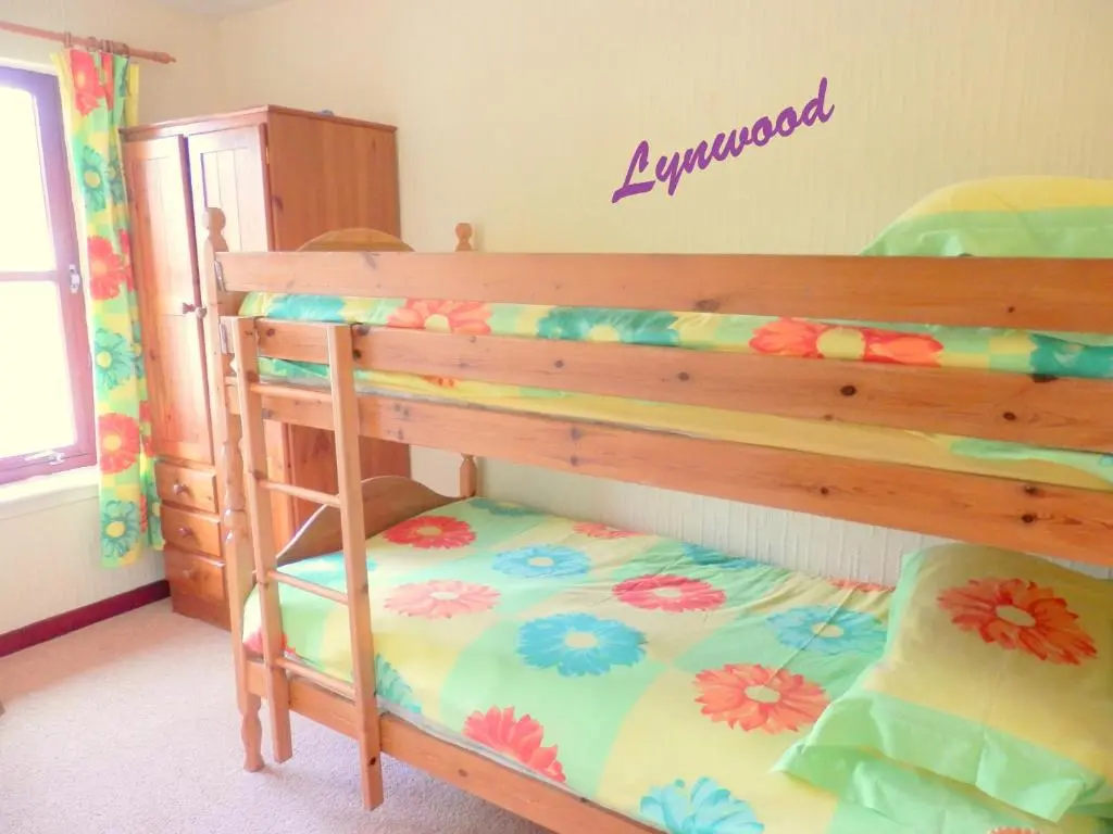 a bedroom with a bunk bed with a flower pattern at Cairngorm Highland Bungalows in Aviemore