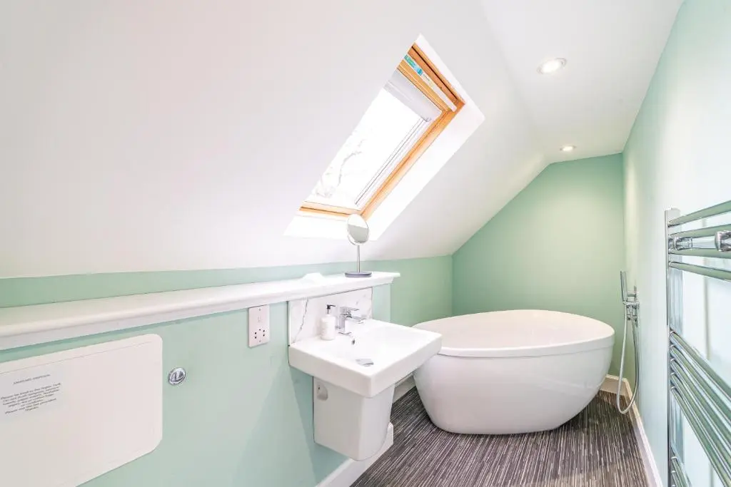 a bathroom with a sink and a toilet and a window at Gardener\u2019s Cottage with Hot Tub in Blairgowrie