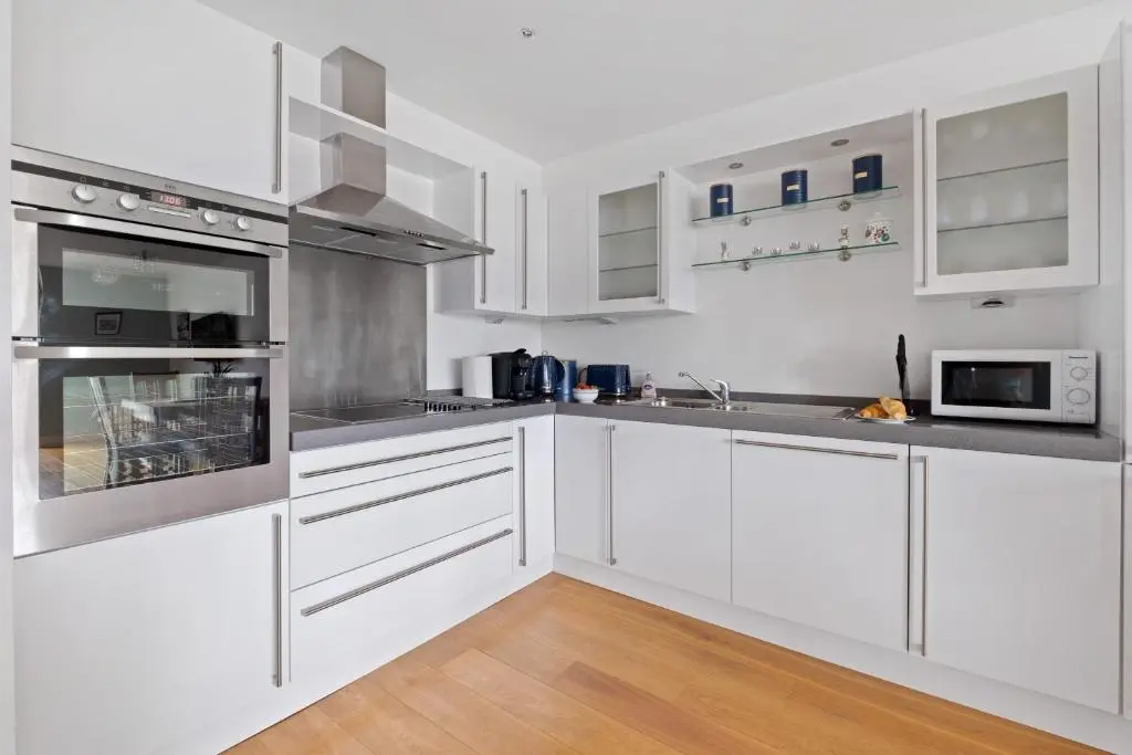 a kitchen with white cabinets and stainless steel appliances at By the Bridge by Toppo in Inverness