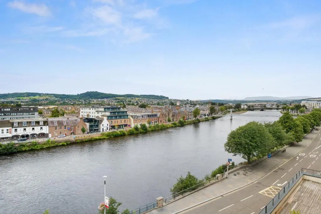 a view of a river in a city at By the Bridge by Toppo in Inverness