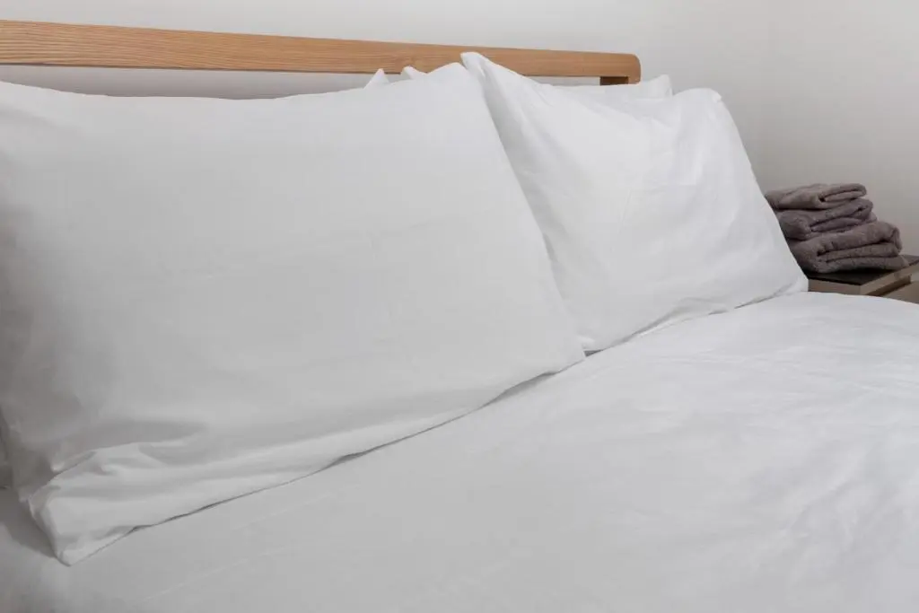 an unmade bed with white sheets and pillows at By the Bridge by Toppo in Inverness