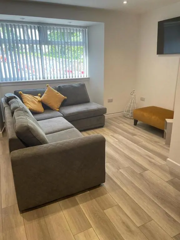 a living room with a couch and a wooden floor at Simpsons in Lairg