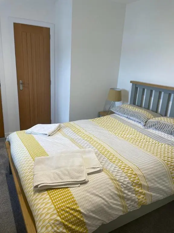 a bedroom with two beds with towels on them at Simpsons in Lairg