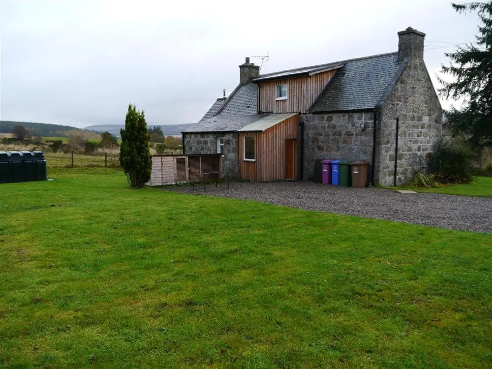 an old stone house with a large grass yard at Bogroy in Aberlour