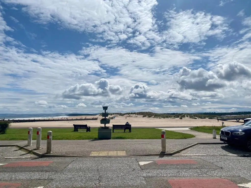 a car parked in a parking lot with benches at Seaview in Lossiemouth
