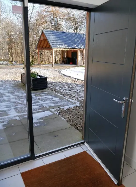 an open door with a view of a barn at Laundry Cottage in Aberlour