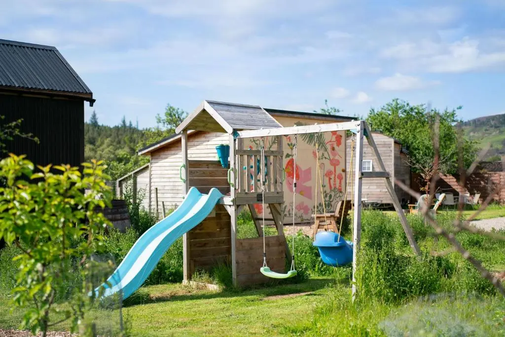 a playground with a slide in a yard at Ailsa- Enchanting Tiny House with wood burner and hot tub in Cairngorms in Ballater