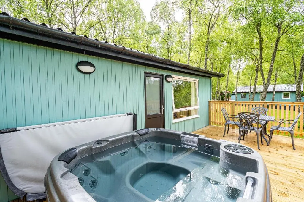 a hot tub on the deck of a house at Bracken Lodge 15 with Hot Tub in Belladrum