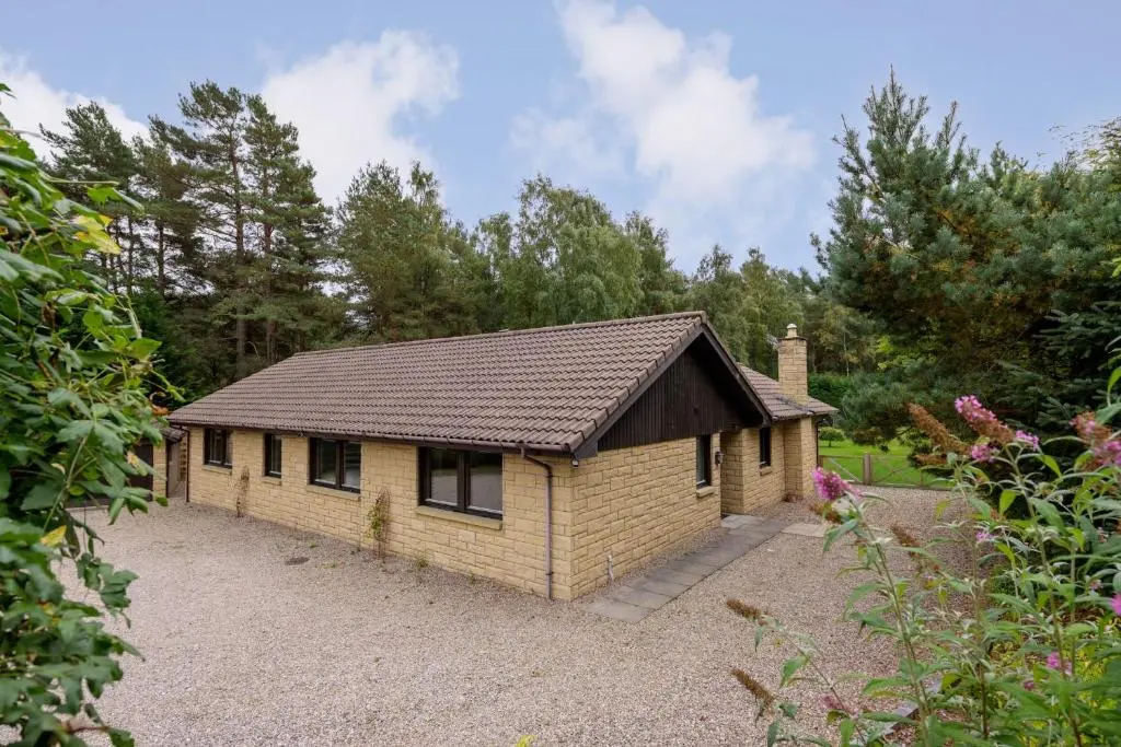 a small house in a yard with trees at Ballater Bungalow - 4 bed - Beautiful Garden in Ballater