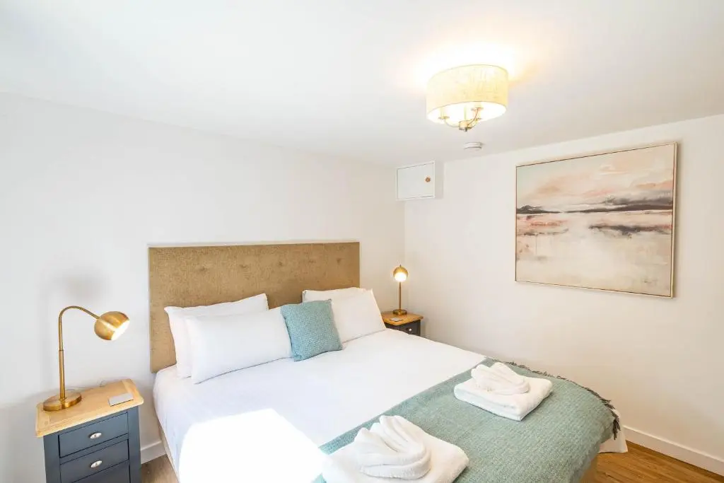 a bedroom with a bed with two white towels on it at Gorse Lodge 9 with Hot Tub in Belladrum