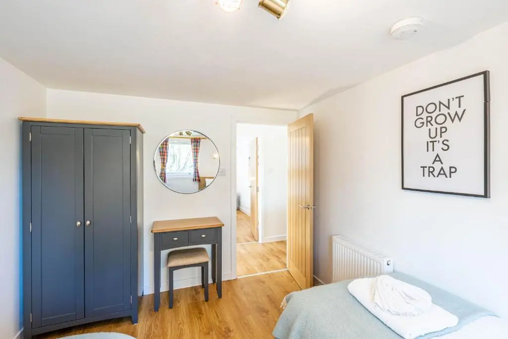 a bedroom with a bed and a mirror and a desk at Gorse Lodge 9 with Hot Tub in Belladrum