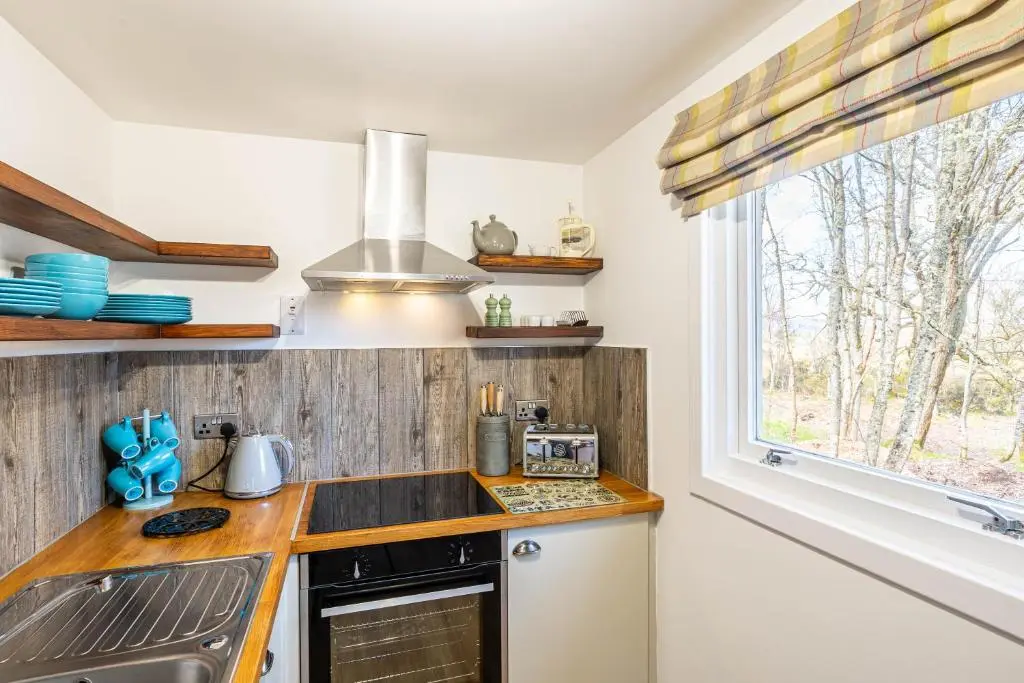 a kitchen with a sink and a stove and a window at Gorse Lodge 9 with Hot Tub in Belladrum