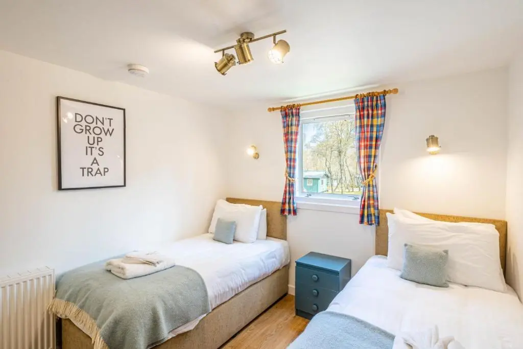 a bedroom with two beds and a window at Gorse Lodge 9 with Hot Tub in Belladrum