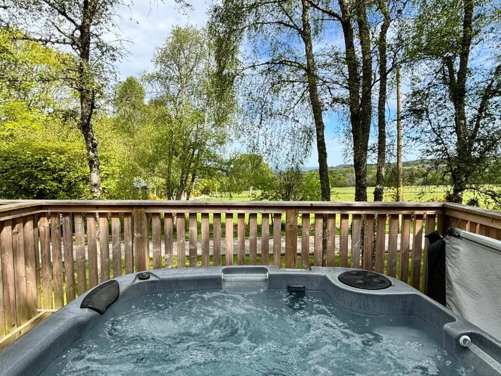 a hot tub sitting on a wooden fence at Heather Lodge 1 with Hot Tub in Belladrum