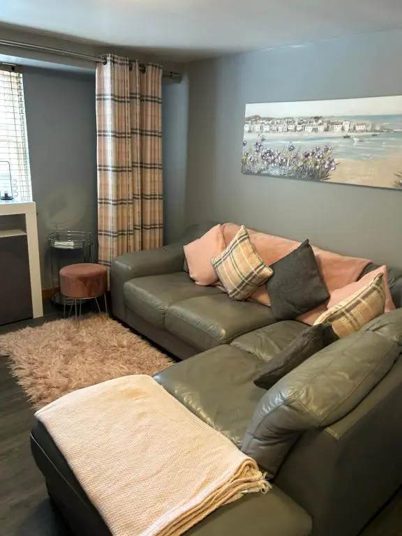 a living room with a green leather couch at Saint Blue Apartment in Tain