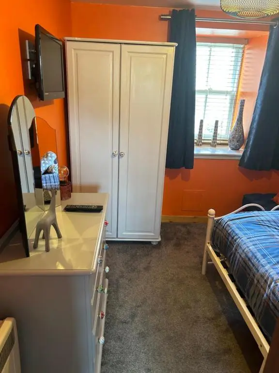 a bedroom with a white cabinet and a bed at Saint Blue Apartment in Tain
