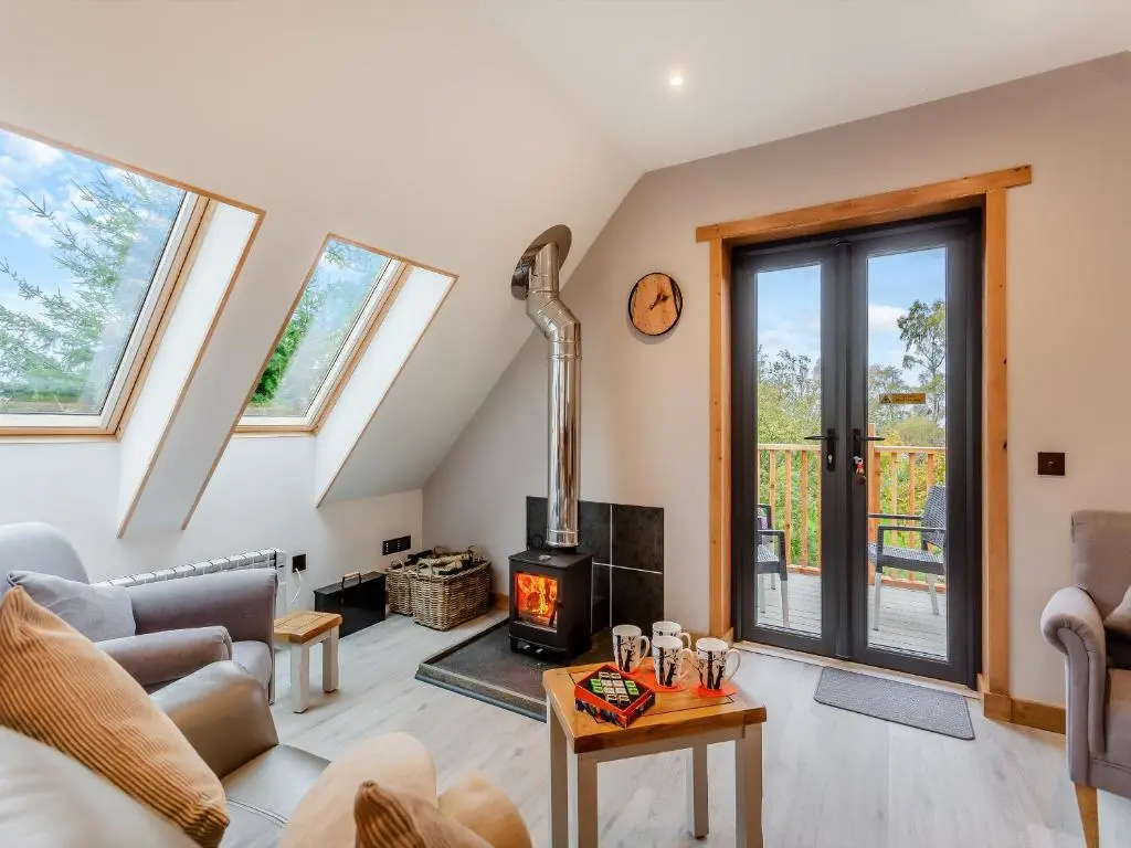 a living room with a couch and a fireplace at Tigh-Na-Sgoile in Belladrum