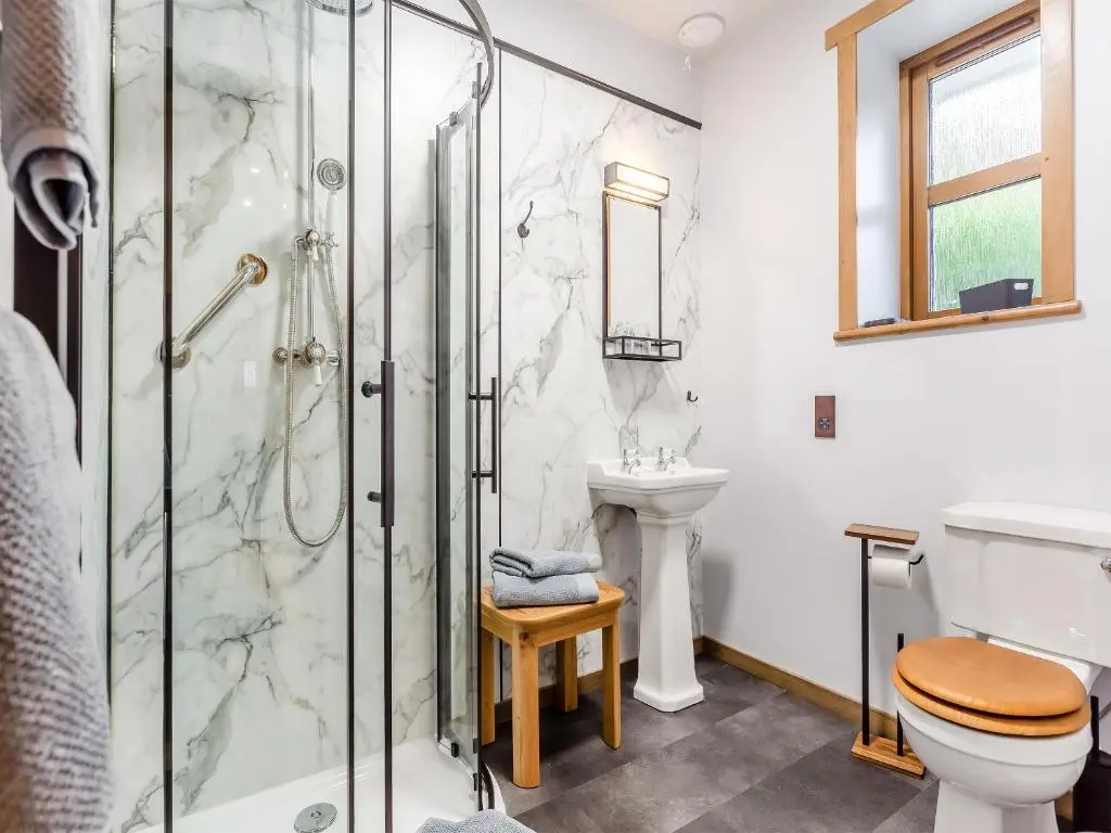 a bathroom with a shower and a toilet and a sink at Tigh-Na-Sgoile in Belladrum