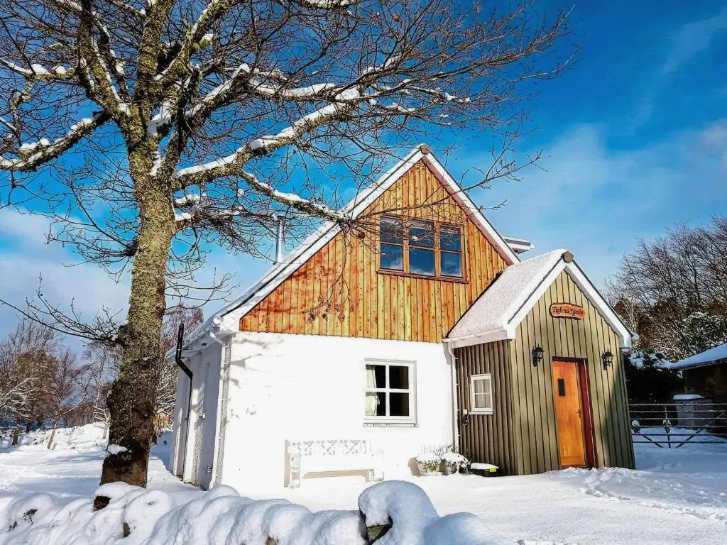 a small barn with a tree in the snow at Tigh-Na-Sgoile in Belladrum