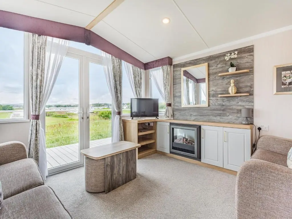 a living room with a tv and a fireplace at The Bordeux in Dornoch
