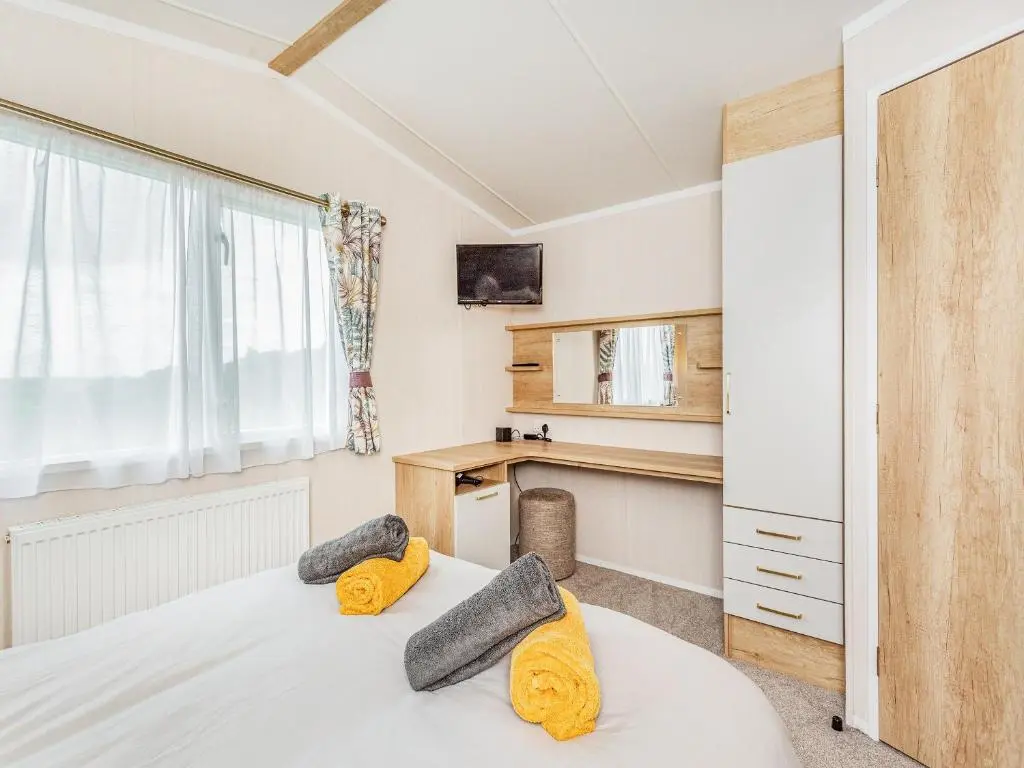 a bedroom with a bed with yellow pillows on it at The Bordeux in Dornoch